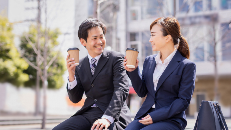 コーヒーを持つ男女