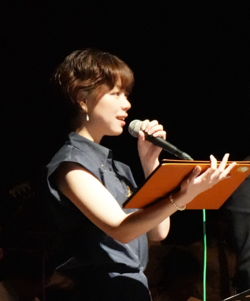 マイクに向かう女性